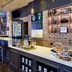 Four Points by Sheraton Munich Arabellapark bar with stools, lit shelves, and coffee display in Munich