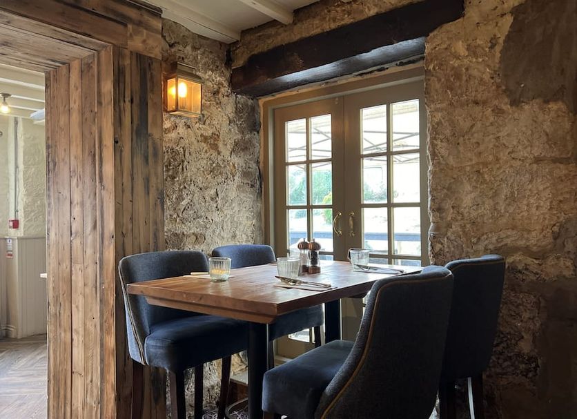 The Forresters Arms Kilburn in York dining nook with wooden table, navy chairs and window view