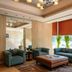 Royal Orchid Central Jaipur lounge with teal sofas, ottoman, large mirror and city view windows