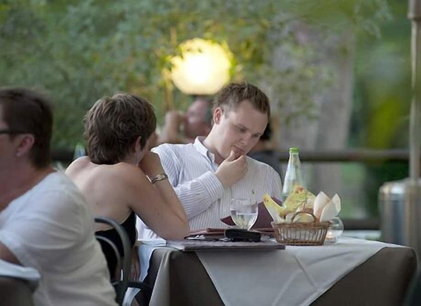 Guests dining outdoors at Hotel Ristorante Molino D'era in Volterra, with table setting and garden backdrop