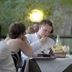 Guests dining outdoors at Hotel Ristorante Molino D'era in Volterra, with table setting and garden backdrop