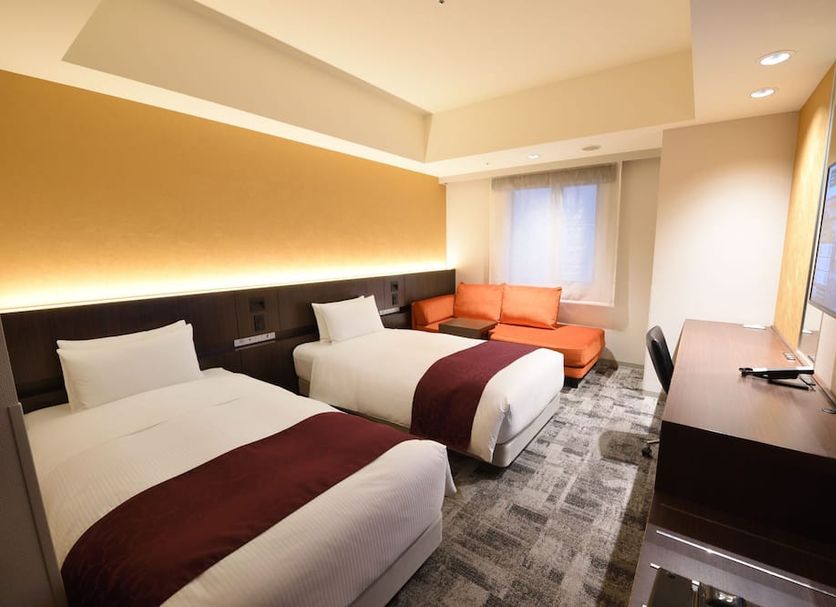 Hakata Green Hotel Annex in Fukuoka twin room with two beds, sofa, and wall-mounted TV