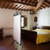 Agriturismo Villa La Morina in Cortona room with wood-beamed ceiling, bed, and small dining table