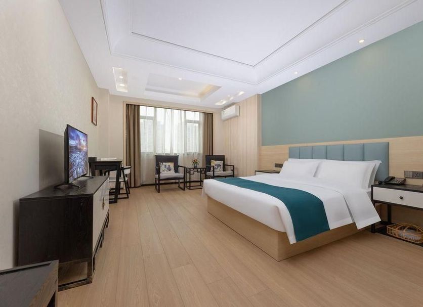 Days Inn by Wyndham Wuxi Shengma guest room in Wuxi with king bed, TV, desk and large window