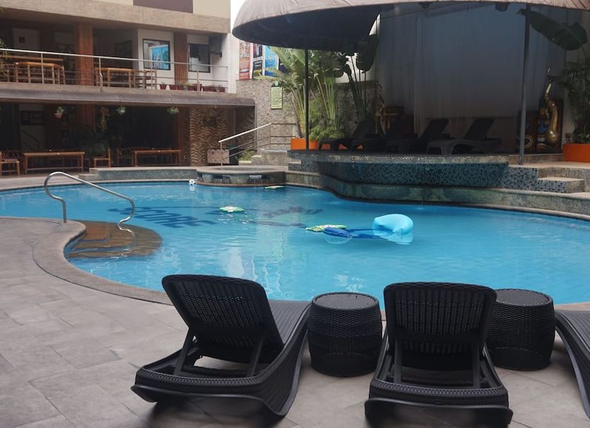 Score Birds Hotel, Angeles City: outdoor pool with lounge chairs and shaded seating area