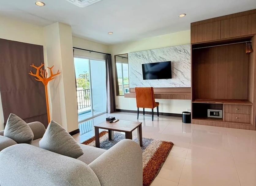 Phavina Hotel & Grand Boutique Rayong suite with sofa, desk, TV, and balcony view in Rayong
