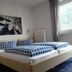 Pension Sonnalp in Ortisei guest room with double bed, checkered bedding, bedside tables and window