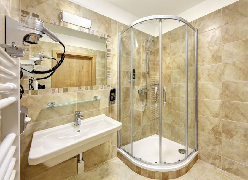 Martin Hotel Prague bathroom in Prague with corner glass shower, wall-mounted sink and beige tile