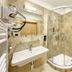 Martin Hotel Prague bathroom in Prague with corner glass shower, wall-mounted sink and beige tile