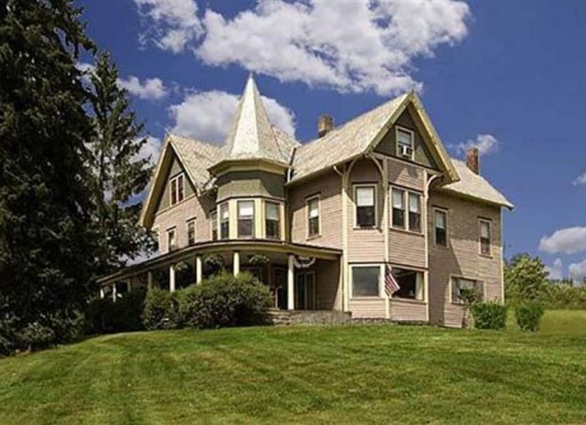 Margaretville Mountain Inn B&B in Margaretville, Victorian inn on a grassy hill under a blue sky