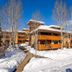 Canyon Creek in Steamboat Springs, snowy lodge-style hotel exterior with trees and walkway