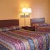 Executive Inn Rocky Top room with two beds, bedside lamp and warm orange walls