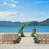 The St. Regis Langkawi beach wedding setup with floral arch, chairs, turquoise sea and mountains