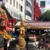 The Park Residence in Bangkok, street view with ornate shrine and golden statues outside the hotel