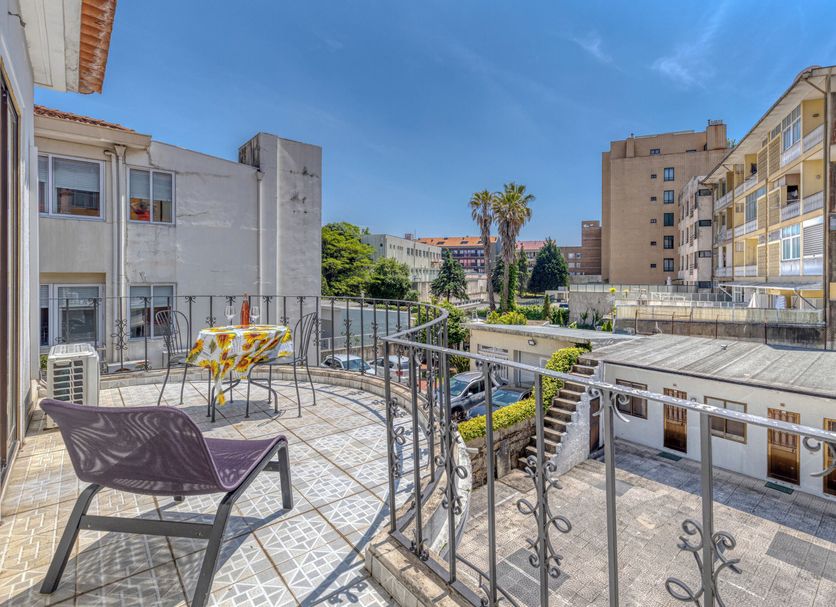 Hotel Borsalino in Porto balcony terrace with chairs and city buildings under a blue sky