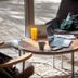 The Originals City, Angers Sud, Le Village 49 lounge with round table, laptop, chairs and sunlight