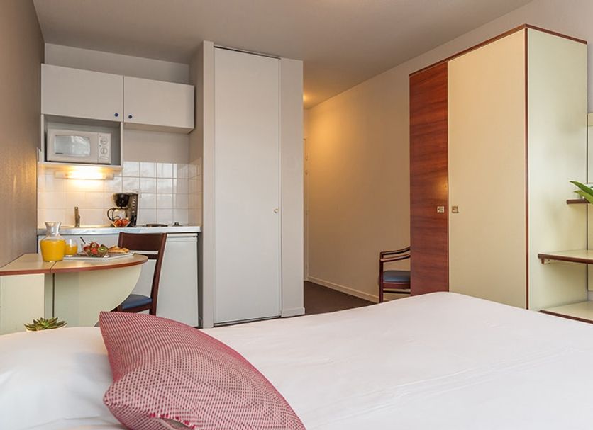 Appart'City La Rochelle studio room with kitchenette, bed, wardrobe and desk in La Rochelle