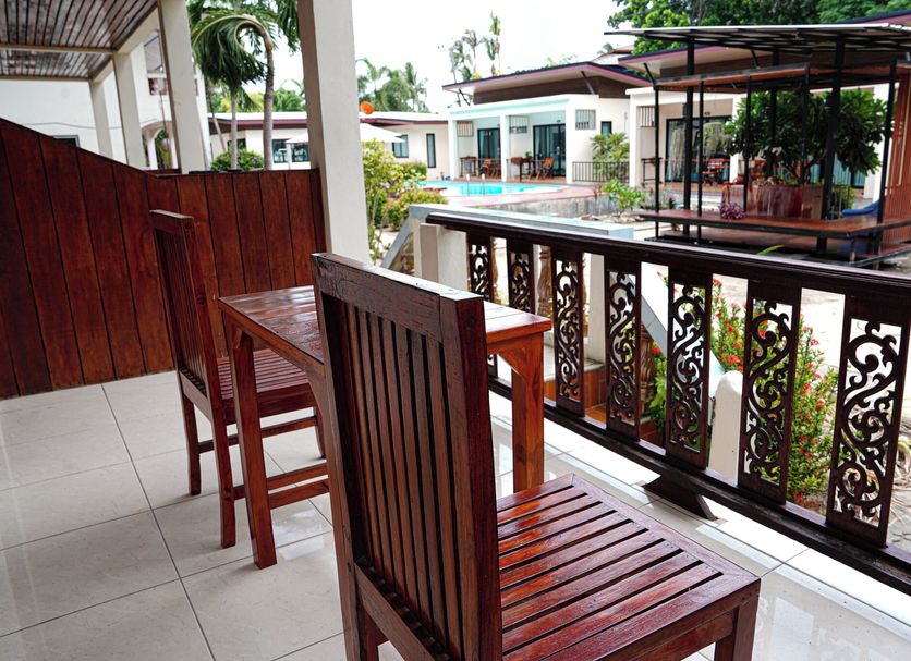 JP Resort Koh Tao balcony with wooden chairs overlooking the pool and resort courtyard in Ko Tao