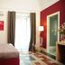 Sangiuliano114 B&B in Catania guest room with bed, balcony doors, floor lamp, and red accent wall