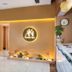 Super Candle Hotel Hanoi spa reception with illuminated logo, glass door, marble counter and plant accents
