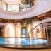 Alpenhotel Tirolerhof in Neustift im Stubaital: indoor circular pool beneath a curved balcony