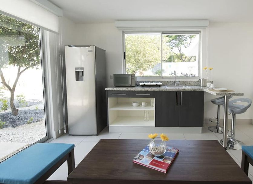 Hotel Nicte Managua kitchen nook with mini fridge, counter, bar stools and garden view