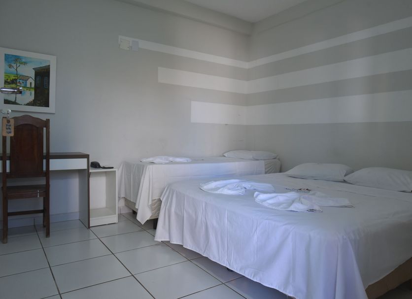 Hotel Pousada Mato Grosso in Campo Grande room with two white beds, desk and tiled floor