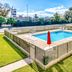 OYO Hotel Houston Southwest I-69 in Houston, outdoor fenced swimming pool with red umbrella
