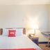 Budgetlodge Oklahoma City guest room with a neatly made bed, bedside lamp, and desk