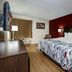 Red Roof Inn Hillsville guest room with king bed, red accent wall, TV and window with curtains