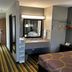Super 8 by Wyndham Mound City guest room with bed, desk, vanity and striped carpet