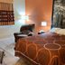 Super 8 by Wyndham Altoona guest room with queen bed, armchair, bedside lamp and wall art