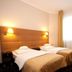 La Petite Apartments & Rooms in Gdansk: twin beds in a bright hotel room with large window and curtains