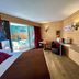 Résidence Côté Chalet in Thonon-les-Bains room with patio doors, balcony view, desk and wall-mounted TV