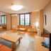 Colosseum Inn Tateshina guest room with tatami floor, twin beds, table seating, and large windows