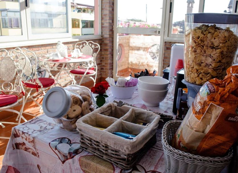 Breakfast buffet at Villa Erasi in Fiumicino with pastries, cereal and seating by bright windows