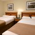 Medicine Hat Suites in Medicine Hat guest room with two double beds and bedside lamp