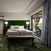 Grand Bohemian Lodge Greenville, Autograph Collection guest room with balcony view and green accent wall