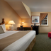 St. Eugene Golf Resort & Casino in Cranbrook guest room with fireplace, desk, armchair, and windows