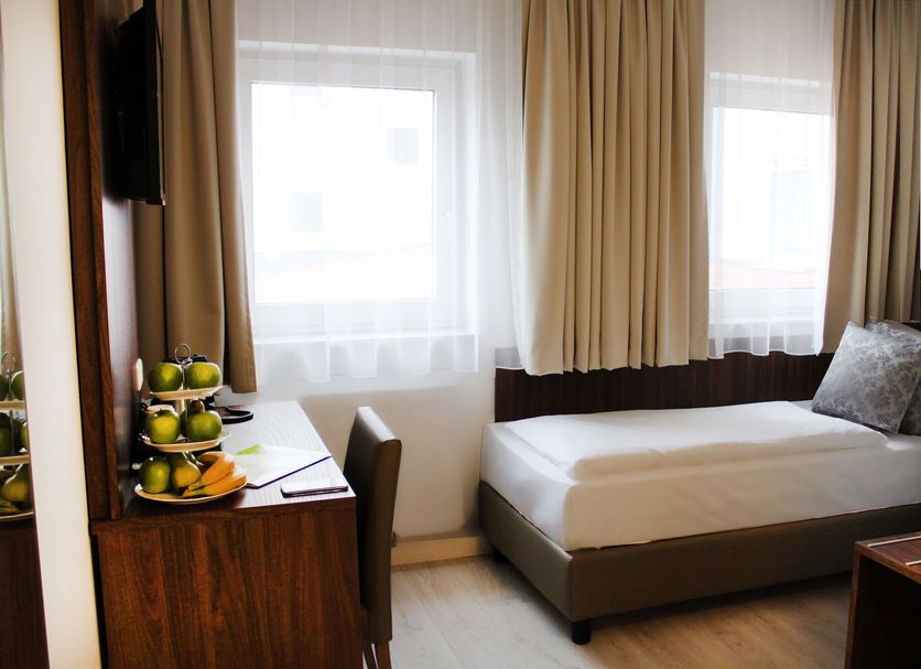 Anor Hotel & Conference Center Frankfurt Airport room with single bed, desk and fruit tray in Mörfelden-Walldorf