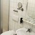 Garni-Hotel Adler Ostfildern bathroom with sink, mirror, towel rack, and shower area