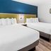 SureStay by Best Western Santa Monica room with two queen beds and blue accent wall