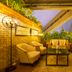 Hotel Eclat Beijing lounge terrace with armchairs, coffee table, plants and brick walls in Beijing