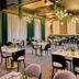 Artis Loft Hotel Mszczonów dining room with set tables, black chairs, and hanging lights