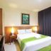 Mirah Hotel & Resort Banyuwangi guest room with double bed, desk, lamps and dark curtains