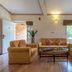 Vijayshree Resort, Hampi living room with tan sofas and a coffee table in Hosapete