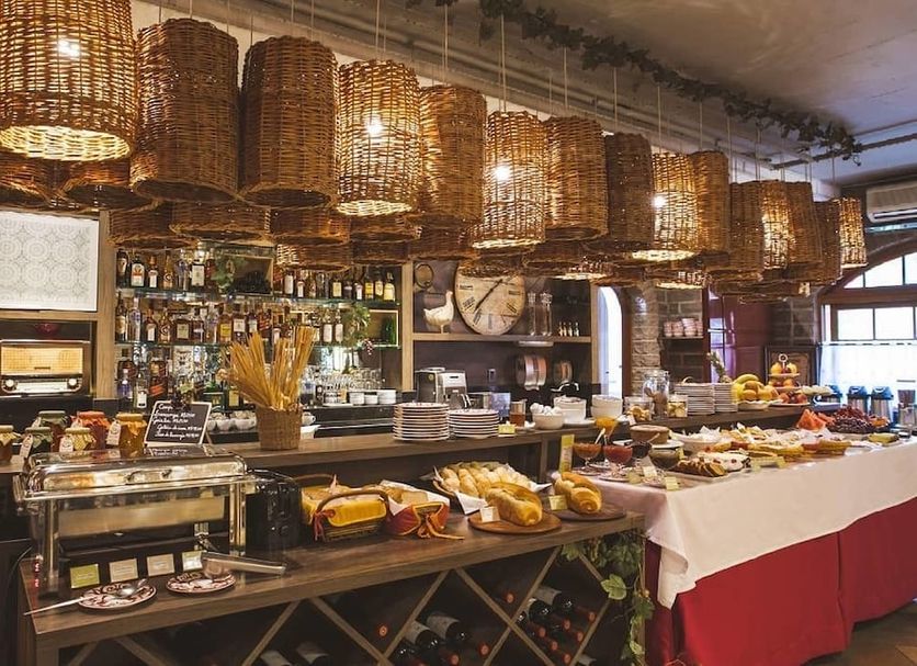 Pousada Castello Benvenutti breakfast buffet and bar area in Bento Gonçalves with woven pendant lights