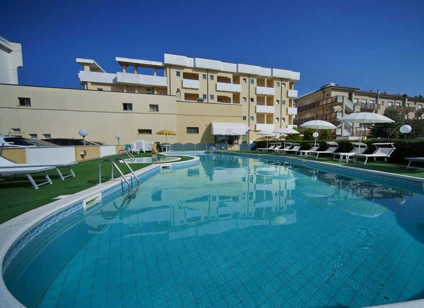 Park Hotel Serena in Rimini with outdoor pool, sun loungers and hotel building under clear blue sky