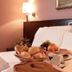 Hotel City, Piacenza guest room with breakfast tray on a bed and lamp by the headboard