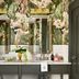 Zelda Dearest Asheville bathroom with double vanity, framed mirrors, and tropical wallpaper